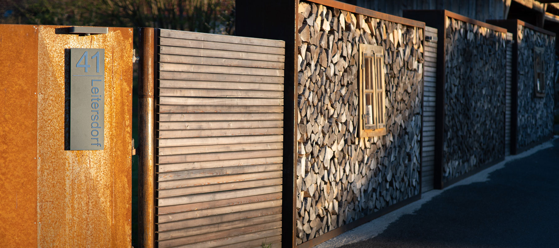 Moderner Holzzaun mit rustikalem Tor, Aufschrift: '41 Leitersdorf'